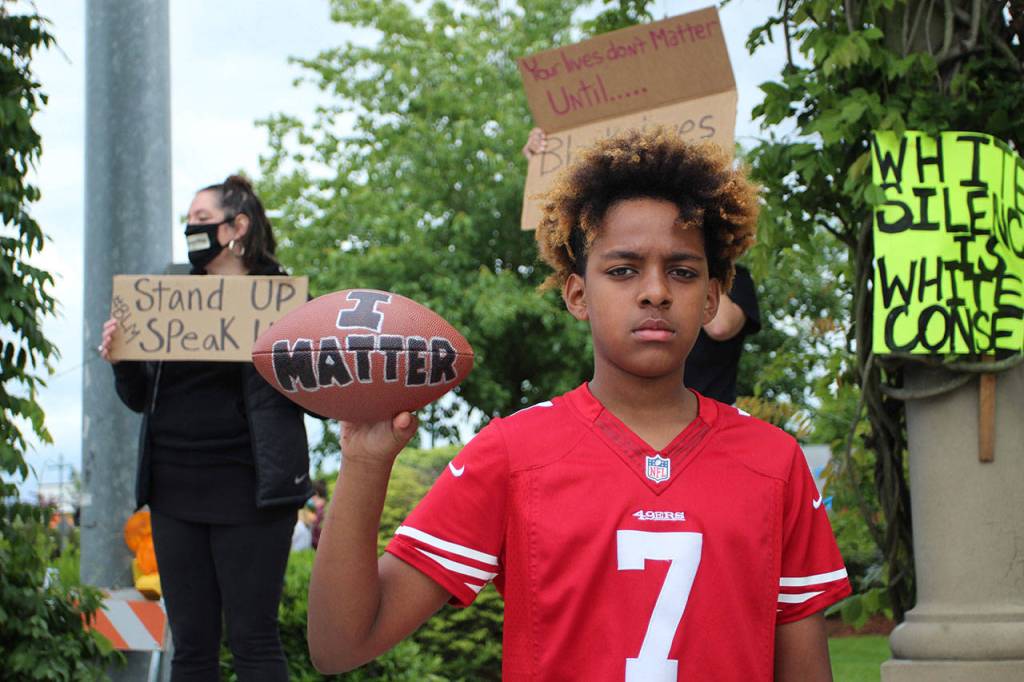 12-year-old Doni Burkett holds a football reading I Matter while wearing a Collin Kaepernick jersey on Sunday, May 31 in Federal Way. Olivia Sullivan/staff photo