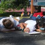 Seniors Christina Manning, left, and Meher Dholakia hold hands during the eight minutes of silence when protesters laid on the ground outside of Thomas Jefferson High School to honor the life of George Floyd on June 10. Olivia Sullivan/staff photo