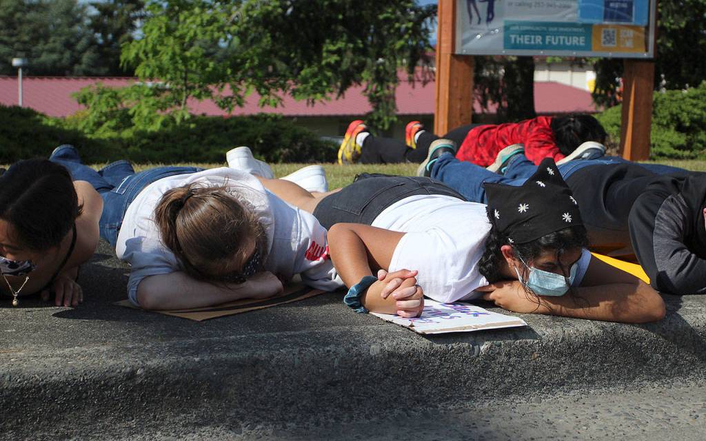 Seniors Christina Manning, left, and Meher Dholakia hold hands during the eight minutes of silence when protesters laid on the ground outside of Thomas Jefferson High School to honor the life of George Floyd on June 10. Olivia Sullivan/staff photo