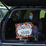 A Decatur staff member takes cover from the rain while celebrating the graduating class of 2020.