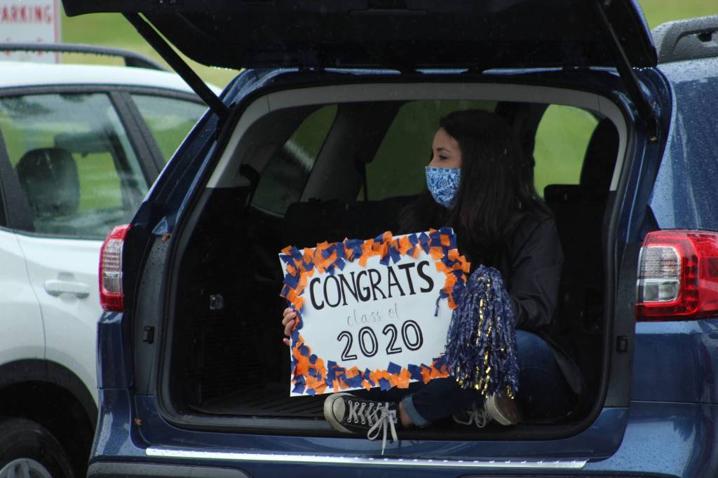 A Decatur staff member takes cover from the rain while celebrating the graduating class of 2020.