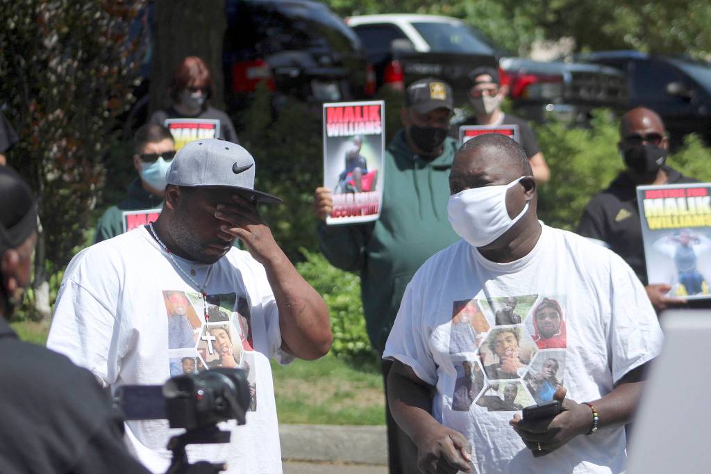 Marvin Phelps Jr., left, is overcome with emotion as he and Marvin Phelps, right, speak to the crowd at a protest in support of justice for Malik Williams on June 28. Olivia Sullivan/staff photo