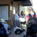 Volunteers Irene Gunnette, left at table, and Debra Mastrobattisto, right at table, hand out items to homeless individuals on Thursday, Aug. 27. Items at the SOS table include toilet paper, deodorant, toothbrushes, clothing and more. Olivia Sullivan/staff photo