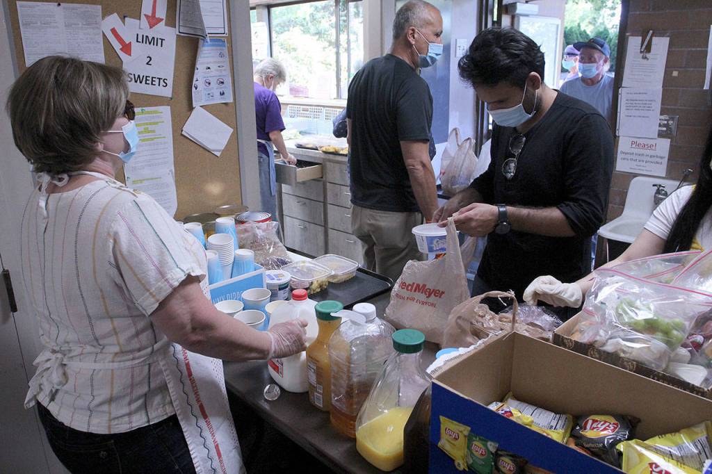Volunteers helps package meals and hand out beverages on Aug. 27 at Calvary Lutheran Church in Federal Way. Olivia Sullivan/staff photo