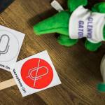 Adams raises these signs to ask students to use their microphones while teaching through online video. (Olivia Vanni / The Herald)