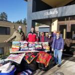 Co-leaders Betty Clifford, far right, and Marjorie Simpson, second from right, meet with local leaders on Dec. 1 to donate handmade items to organizations serving the Federal Way community. Photo courtesy of Roger Flygare