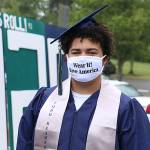 Senior Tayshon Cottrell dons his graduation cap and gown, along with a face mask reading: Wear it! Save America at Todd Beamer High Schools virtual graduation walk recording on May 20 in Federal Way. Olivia Sullivan/staff photo
