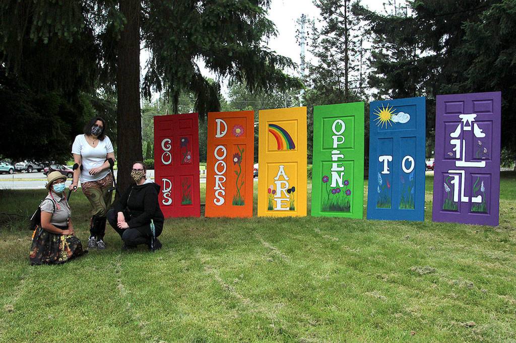 Local artists (pictured left to right) Leann Realiza, Diane Jones Smith and Nici Anderson on June 26 at Wayside United Church of Christ to celebrate the rebuilding of Pride Doors that had been destroyed by vandals the week before. Olivia Sullivan/staff photo