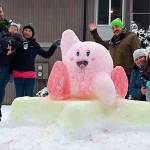 Left-right: Zack, Ray, and Emi Bennight, smile for a photo with Jeff, Kelly, and Karis Cox next to their colorful snow creation of Kirby. Photo courtesy of Zack Bennight