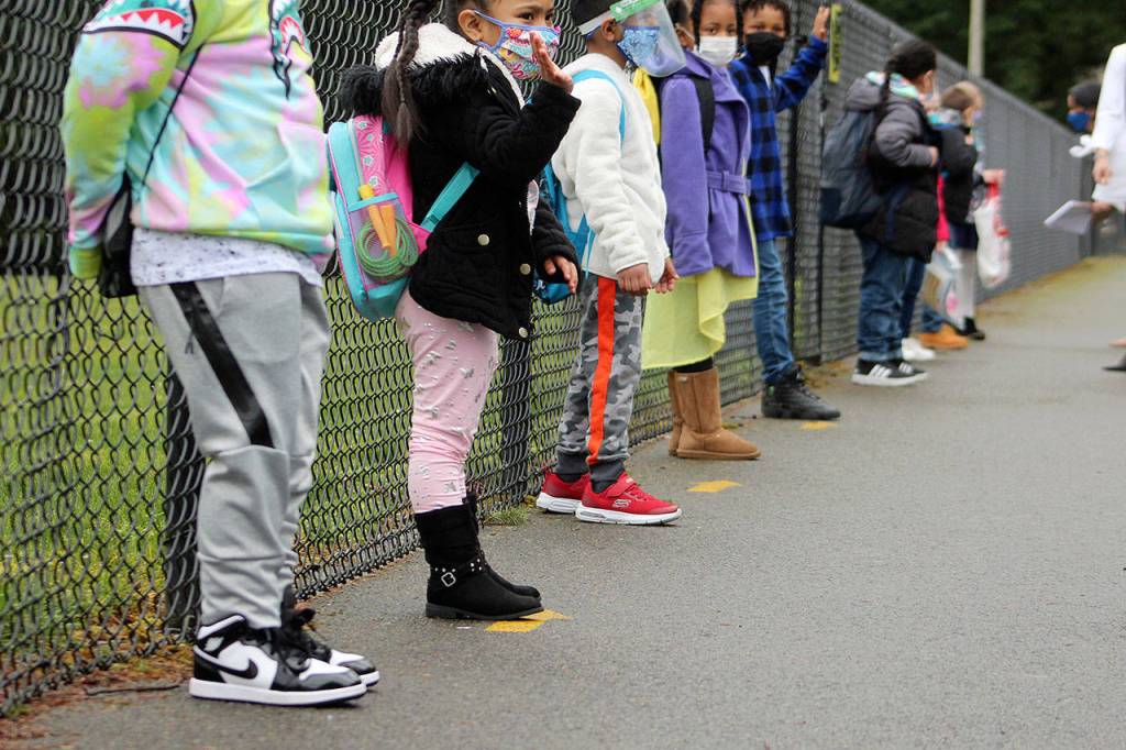 Students line up about six feet apart outside of Panther Lake Elementary for the first day of in-person learning on March 15. Olivia Sullivan/the Mirror