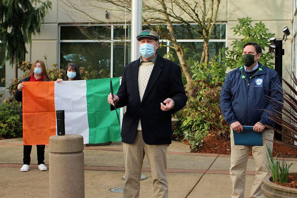 L-R: Audrey Patrick and Anna Patrick hold the Irish flag as Craig Patrick speaks to the crowd after Mayor Jim Ferrell on March 17. Olivia Sullivan/the Mirror