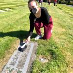 Emma Monson cleans a grave on April 17 in preparation to upload a photo of the grave to BillionGraves. Photo courtesy of Sheryl Mackey