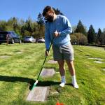 Jacob Keeney cleans a grave on April 17 prior to snapping a photo and uploading the information to BillionGraves. Photo courtesy of Sheryl Mackey