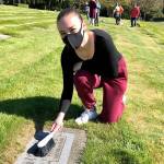 Emma Monson cleans a grave on April 17 in preparation to upload a photo of the grave to BillionGraves. Photo courtesy of Sheryl Mackey