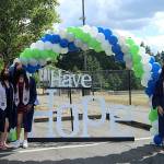 A group of seniors stop for a photo at the Todd Beamer High School car parade sign that reads have hope.