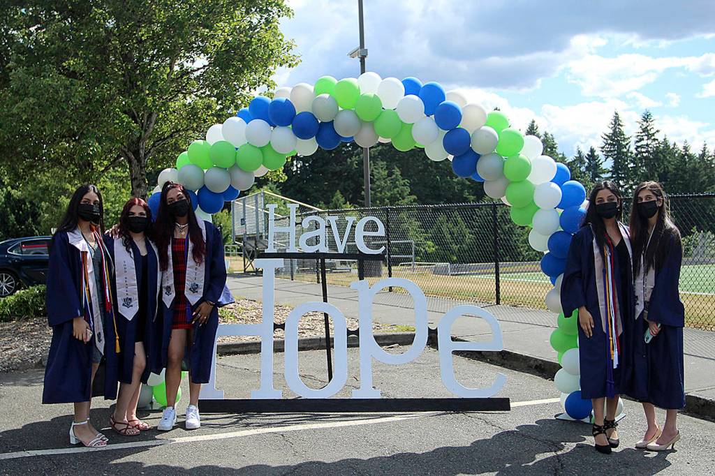 A group of seniors stop for a photo at the Todd Beamer High School car parade sign that reads have hope.