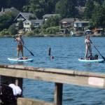 Two paddle boarders watch the dock jumpers while paddling to shore on June 28. Olivia Sullivan/the Mirror