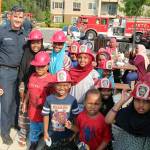 Kids at Kitts Corner Apartments wear their firefighter helmets at National Night Out on Aug. 3. Olivia Sullivan/the Mirror