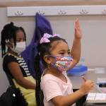 A kindergarten student at Panther Lake Elementary raises her hand during attendance on the first day of in-person learning on March 15. Olivia Sullivan/the Mirror