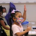 A kindergarten student at Panther Lake Elementary raises her hand during attendance on the first day of in-person learning on March 15. Olivia Sullivan/the Mirror