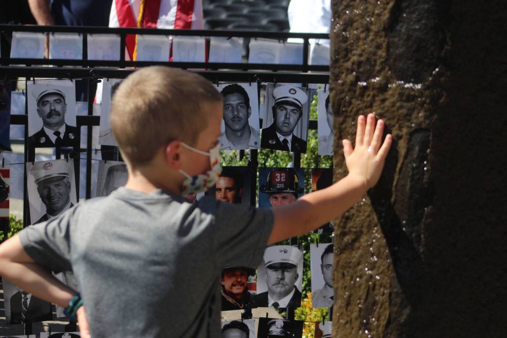 A boy places his hand on the memorial fountain at Station 64 in Federal Way. Olivia Sullivan/the Mirror