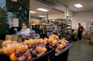 A volunteer packs grocery items into a paper bag at the MSC Food Bank on Wednesday, May 27, 2020. Olivia Sullivan/staff photo