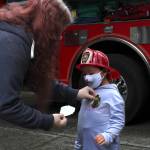 Arianna Graham dons a firefighter helmet and a new badge sticker at Station 62 on Oct. 14. Olivia Sullivan/the Mirror