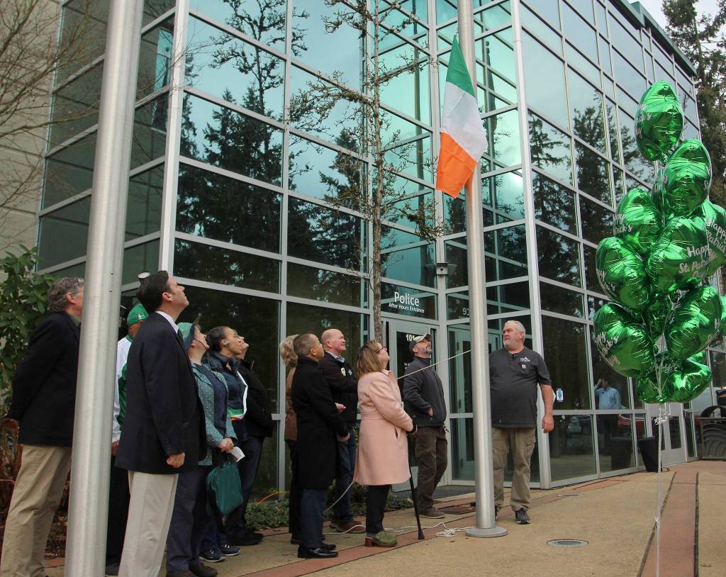 Elected officials and proud community members with Irish heritage assist in raising the Irish flag on March 17.