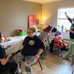 Dr. Loveleen Brar, far left, talks with Suzette Steele at the Pete Andersen FUSION Family Center. Behind, Dr. Sukhi Jassar examines 3-year-old Rowans teeth while big sister Kacie observes on March 18. Olivia Sullivan/the Mirror