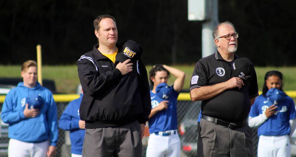 Federal Way National Little League President Charles Heitman, left, and Umpire in Chief Phillip Clark place their hats over their hearts during the National Anthem on April 23. Olivia Sullivan/the Mirror