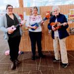 Megan Willan, Jan Barber, and Elna Aki playing ukuleles