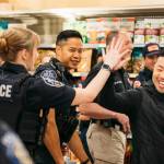 James Byun, far right, Kent Grocery Outlet owner and Battle of the Badge co-organizer, encourages officers at the June 30 competition at the Federal Way Grocery Outlet. COURTESY PHOTO, Kent Police