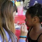 A Federal Way Community Center camp staffer paints a heart-shaped American flag on Naomis cheek on July 4. Olivia Sullivan/the Mirror