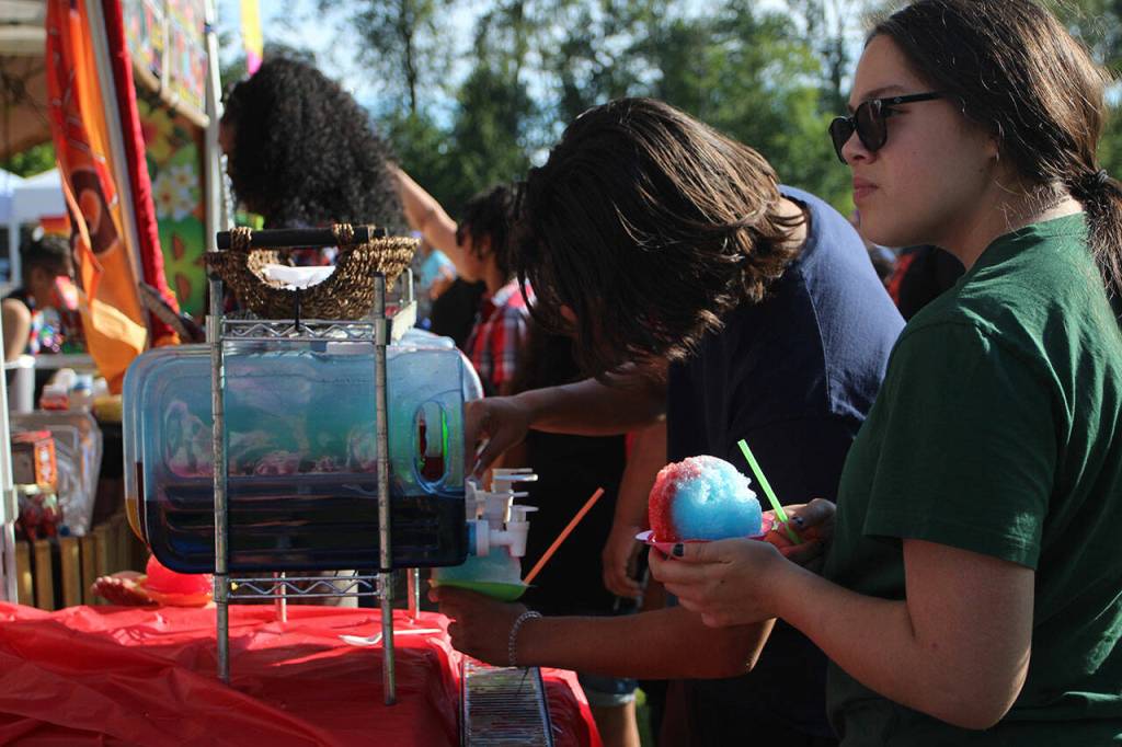 Two people douse their shaved ice from Pac Island Grill in fruity flavors on July 4. Olivia Sullivan/the Mirror