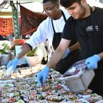 Hassan Obabunmi, left, and Masih Rahmani prepare marinated chicken skewers for Mama Stortinis entry at the Taste of Federal Way.
