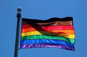 The diversity pride flag flies above Federal Way City Hall in 2021. In addition to the traditional six colors, the flag also includes a black stripe for diversity and a brown stripe for inclusivity. Olivia Sullivan/the Mirror