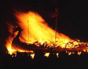 Image by Anne Burgess and used under a Creative Commons Attribution license
This image shows a galley being consumed by flames during a traditional Scottish Up Helly Aa fire festival in 1973. The ceremony marks the end of the Yule season. Once the longship has burned and the flames die down, guizers sing the traditional song The Norsemans Home before going on to a night of partying.
This image shows a galley being consumed by flames during a traditional Scottish Up Helly Aa fire festival in 1973. The ceremony marks the end of the Yule season. Once the longship has burned and the flames die down, guizers sing the traditional song The Norsemans Home before going on to a night of partying. Image by Anne Burgess and used under a Creative Commons Attribution license