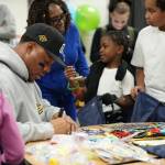 Uchenna Nwosu signs goodie bags for kids at the Federal Way Boys and Girls Club on Dec. 5. Photo courtesy of the Seattle Seahawks