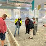 Federal Way Mayor Jim Ferrell and several others survey the work underway at the leisure pool on Dec. 9, which will need additional time for repair due to the discovery of corrosion in the concrete and rebar underneath its tiling. Photo courtesy of the City of Federal Way