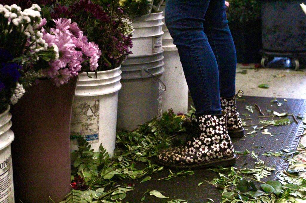 Employee Brianna Sterling dons flowery boots while building flower bouquets on Valentines Day. Olivia Sullivan / the Mirror