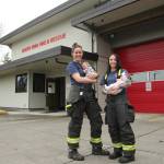 Olivia Sullivan / The Mirror
South King Fire and Rescue Lt. Ann Hoag, left, holds her son Flynn and firefighter Amanda Weed holds her daughter, Parker, outside Station 63 on March 9.