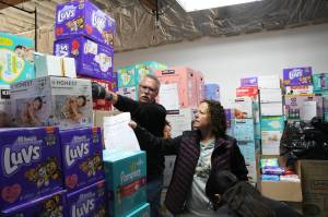 Volunteers move boxes of diapers at Do The Right Things annual diaper drive Wednesday morning.