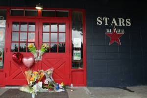 Alex Bruell / The Mirror 
Flowers and candles are left by the door of the Stars Bar & Grill in Federal Way, where two employees were shot and killed early Sunday morning, May 21, 2023. A third man was shot and taken to a hospital. Alex Bruell / The Mirror