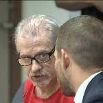 Photo via broadcast video feed. 
Patrick Nicholas, left, consults with defense attorney David Montes on May 25 at the Maleng Regional Justice Center in Kent.