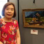 Mischellie Oh stands next to her painting Father and Daughter, which was inspired by a scene she came across during a hike in the Mt. Rainier area. Alex Bruell / The Mirror