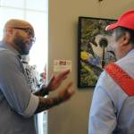 Photographer Robert Chism explains his work Space Needle Reflection to fellow photographer Bruce Honda at the Arts Explosion event. Alex Bruell / The Mirror
