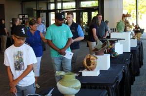 Visitors peruse the displays at the Arts Explosion event Friday afternoon, while a harpist performs in the background. Alex Bruell / The Mirror