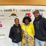 Marlie Love, Tirzah Idahosa and Anthony Love pose for a picture together in front of the Juneteenth event sponsors. (Photo by Joshua Solorzano/The Mirror)