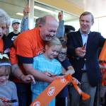 Federal Way City Councilmembers Linda Kochmar and Jack Walsh and King County Councilmember Pete von Reichbauer cut the ribbon on July 27 at the opening of Dicks Drive-In in Federal Way with a little help from some youngsters. Deputy Mayor Susan Honda, also cutting the ribbon, is just out of frame to the left. (Alex Bruell / The Mirror)