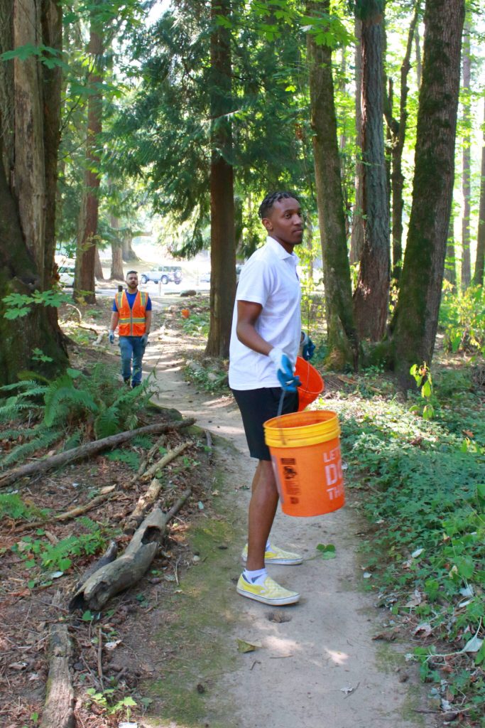 Youth leader Joe Ngemba heads waters plants that AYDEPI volunteers planted at previous events. Photo by Keelin Everly-Lang / The Mirror
